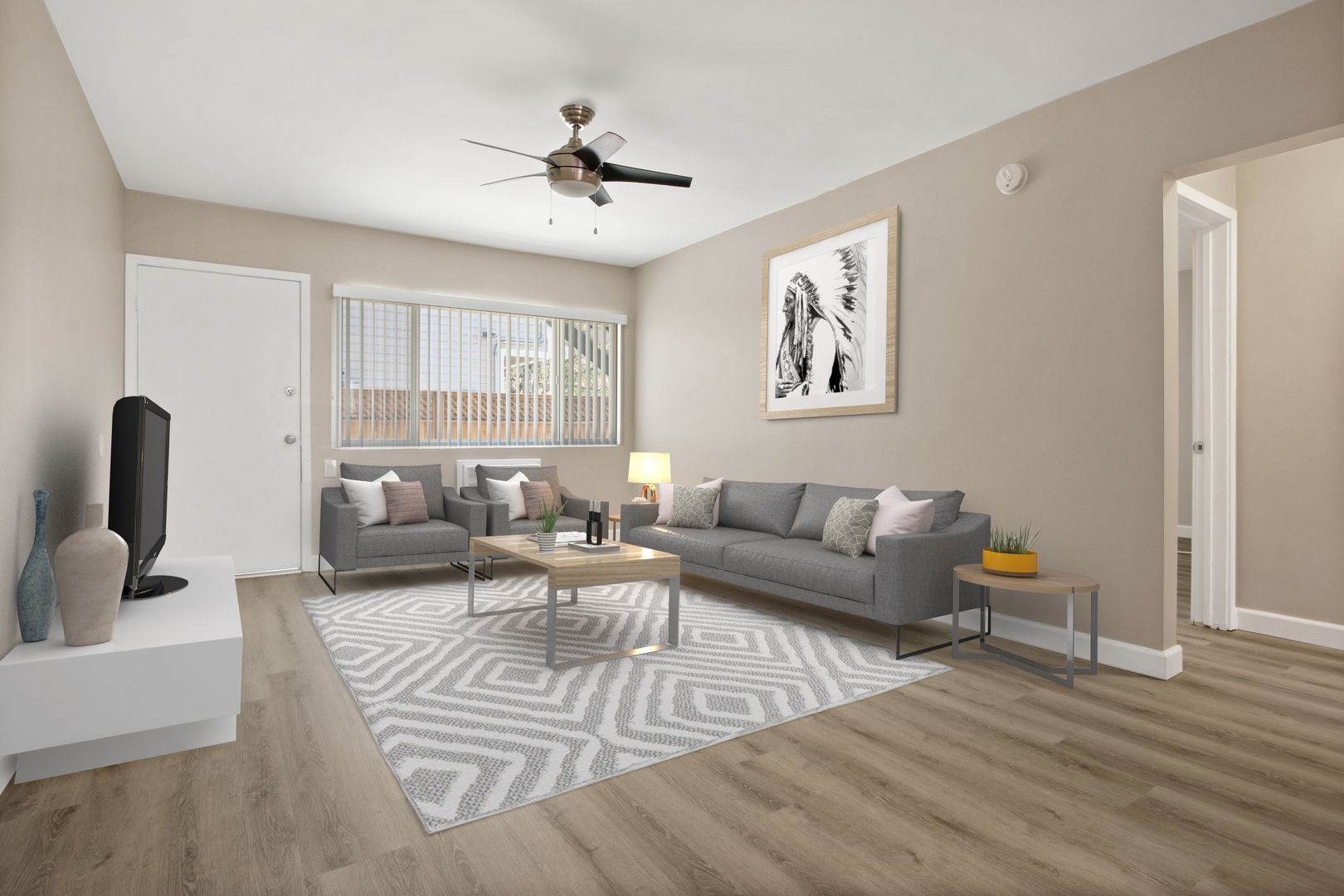 Modern living room with gray sofas, patterned rug, white coffee table, and ceiling fan.