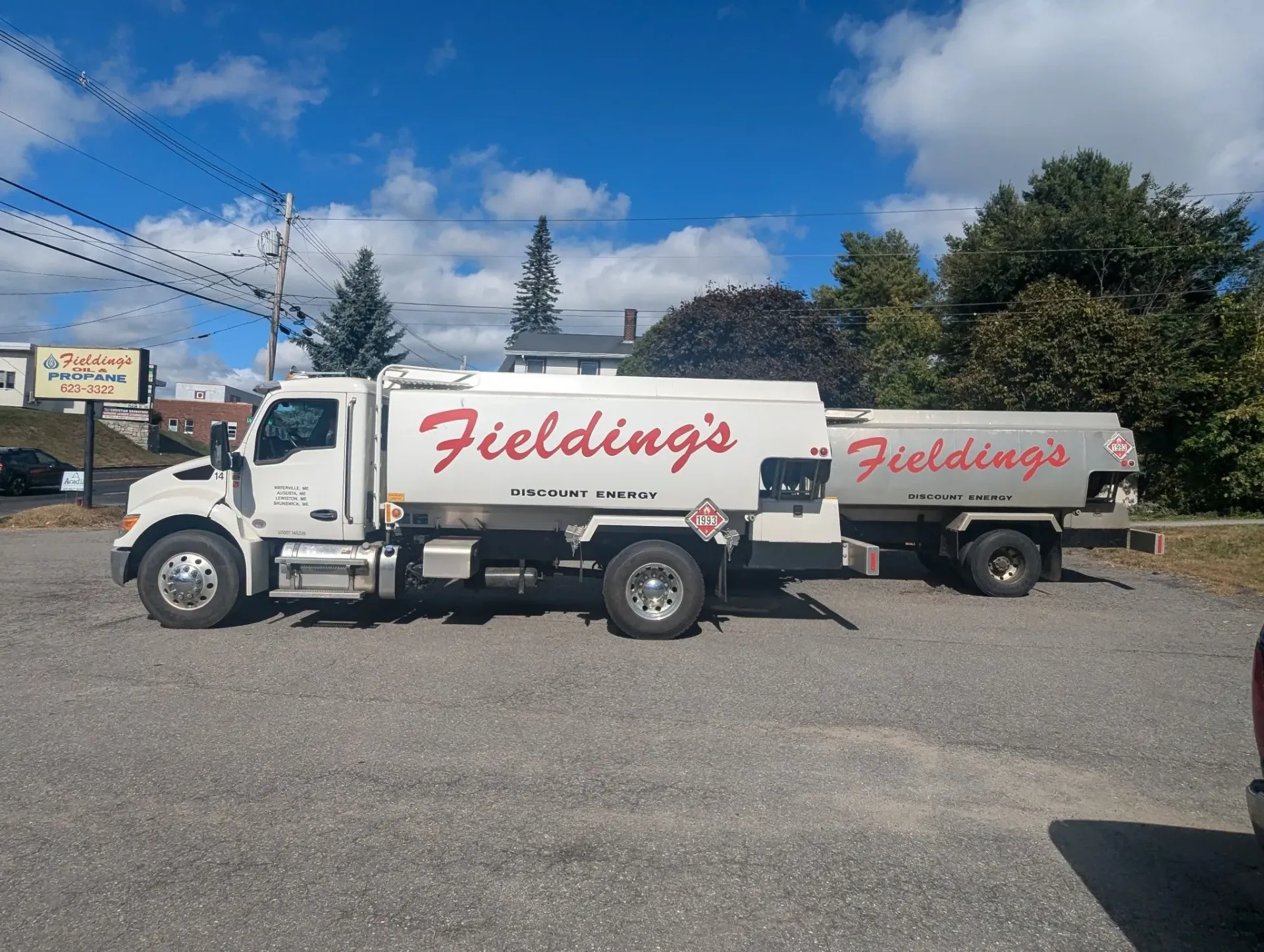 White Fielding's tanker truck and trailer parked on gravel under a blue sky