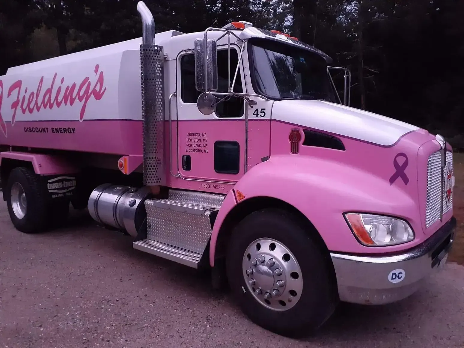 Pink Fielding’s moving truck parked outdoors, with pink ribbon decals and silver trim