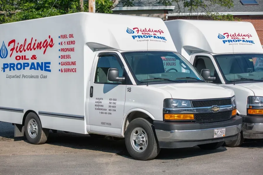 White propane delivery truck with blue and red branding parked outdoors, with a second truck beside it