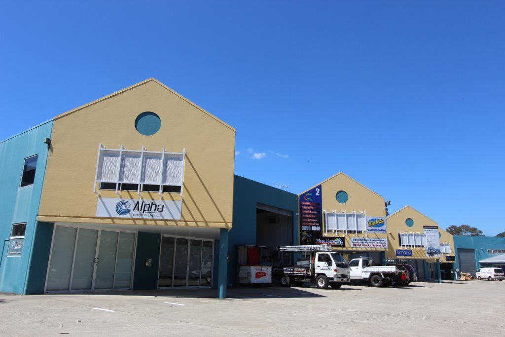 A Row of Buildings With Trucks Parked in Front of Them — Peterson Property Valuations In Caloundra West, QLD