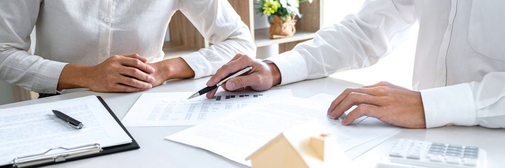 Two People at a Desk Reviewing Documents — Peterson Property Valuations In Beerwah, QLD