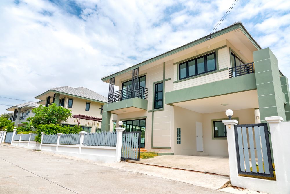 A Large White and Green House With a Fence in Front of It β Peterson Property Valuations In Caloundra West, QLD