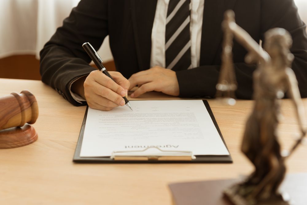 Lawyer Signing a Document, Scales of Justice and Gavel on Desk— Peterson Property Valuations In Caloundra West, QLD