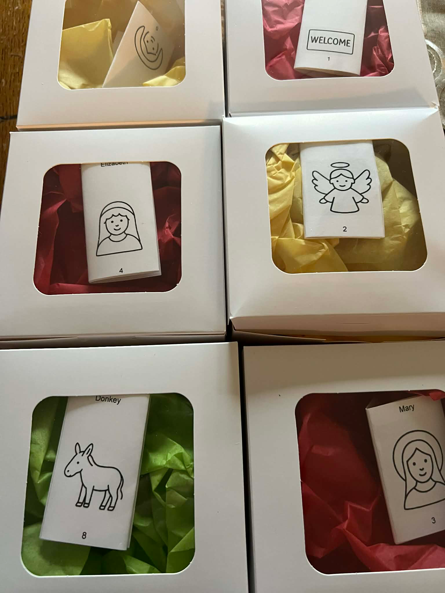 Six gift boxes with colorful tissue paper and small animal doodles on white tags, arranged in a grid.