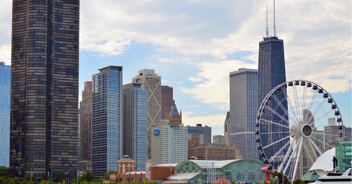 City skyline with tall buildings and a Ferris wheel under a cloudy sky