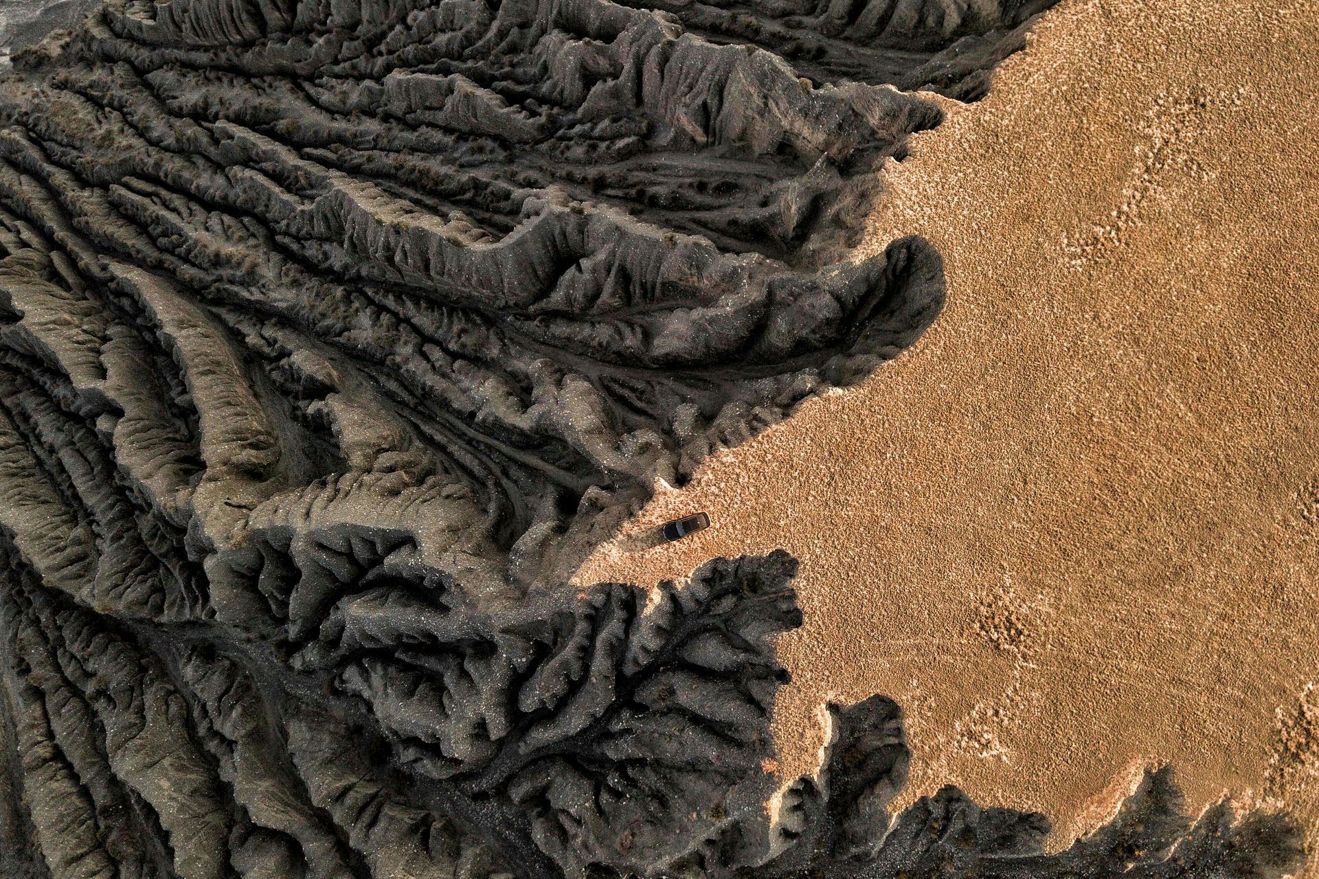 Black furry fabric and tan pebbled surface meeting in an abstract close-up.