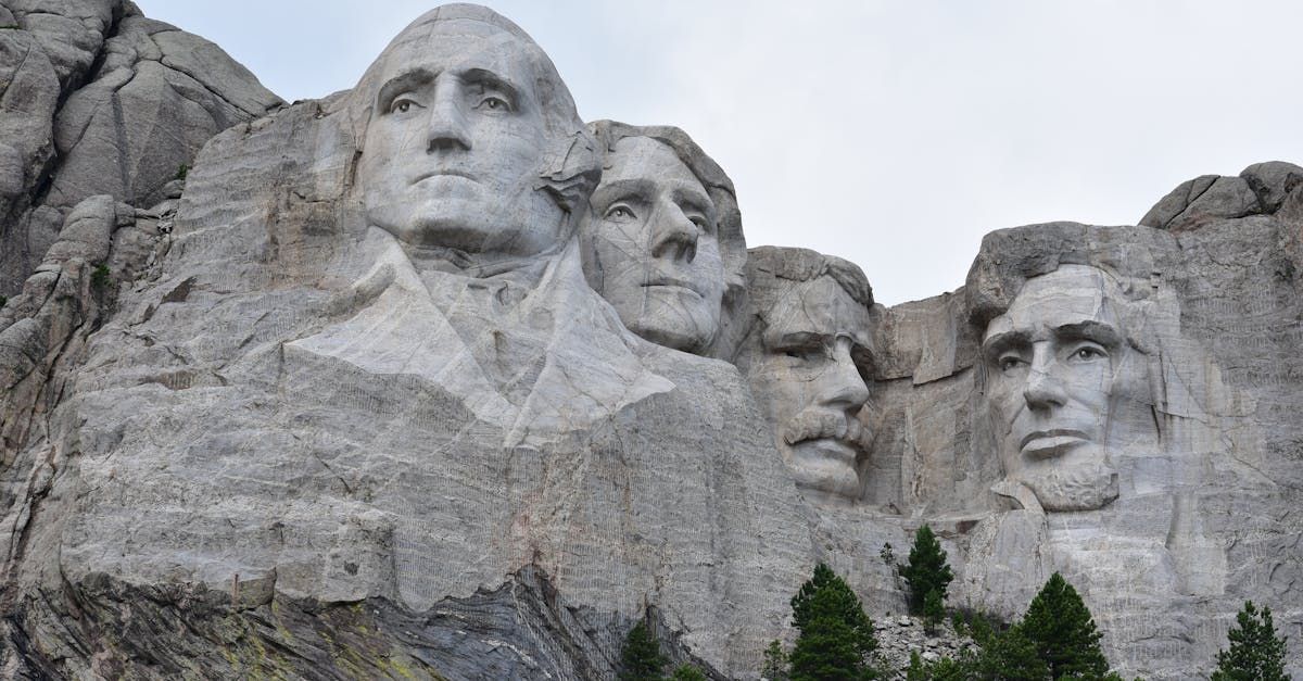 Mount Rushmore National Memorial carved into a granite mountainside under an overcast sky