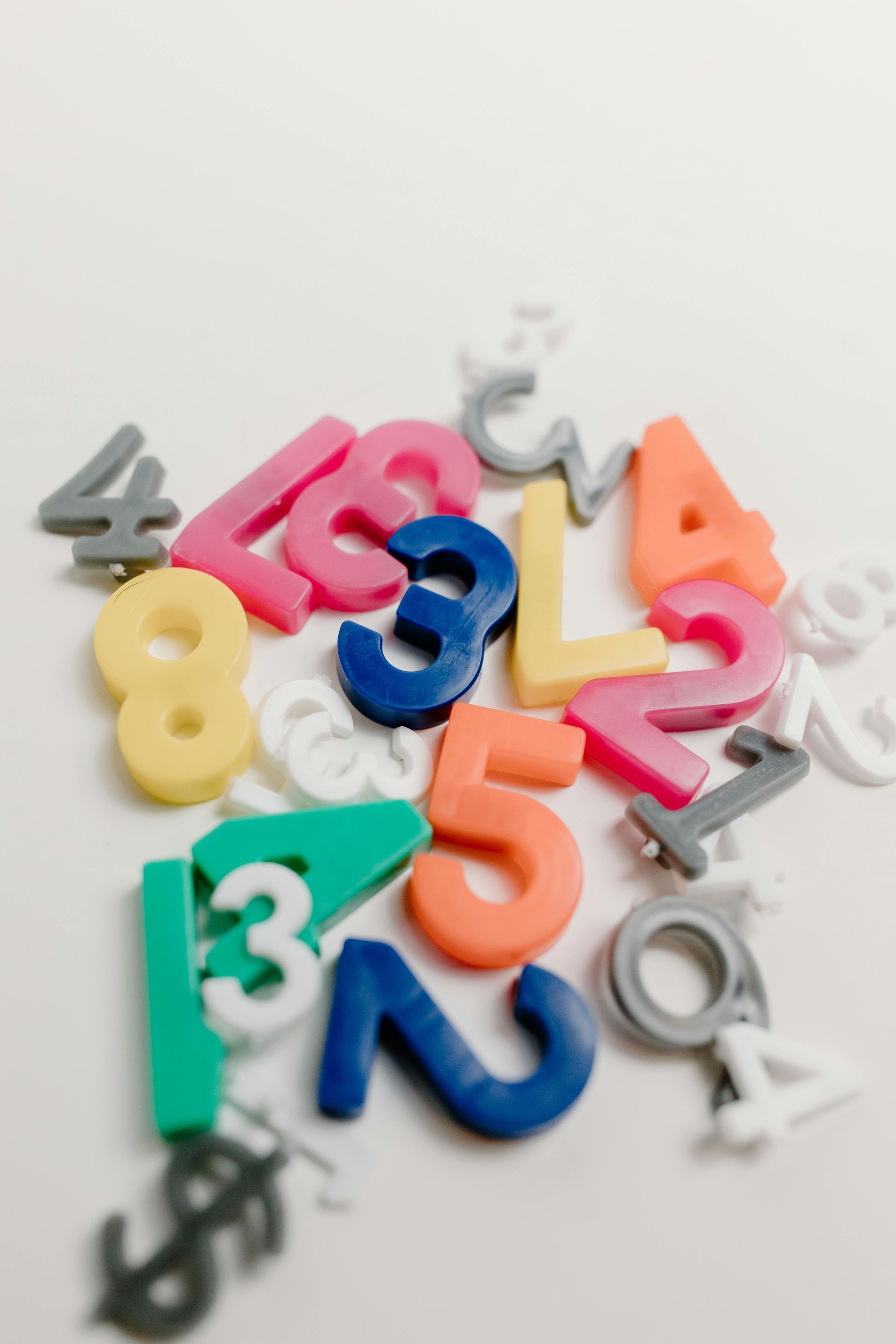 Colorful scattered plastic numbers on a white background