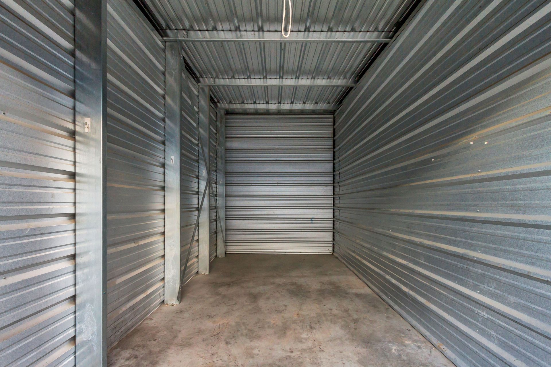 Empty, metal storage unit with corrugated walls, floor, and ceiling.
