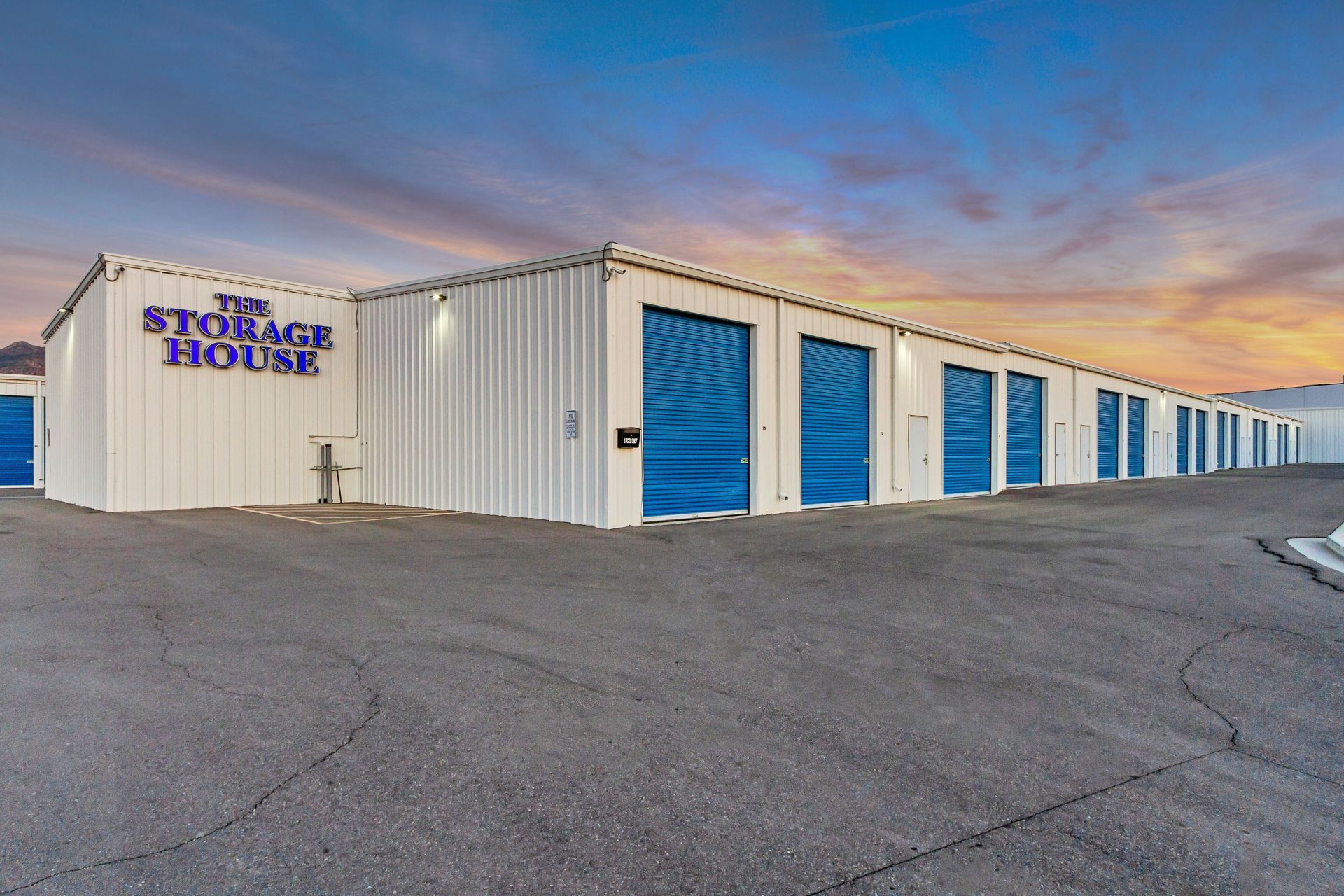Storage facility with white building, blue doors, and 