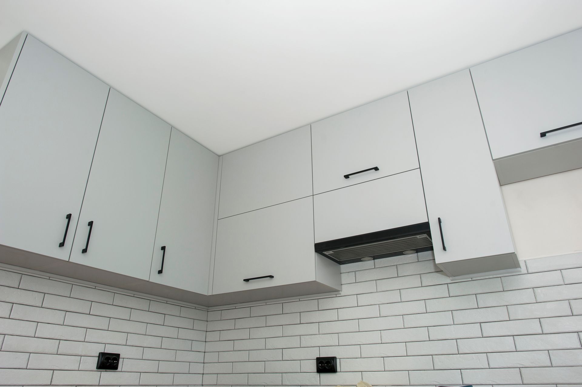 Modern white kitchen cabinets above a white subway tile backsplash Modern white kitchen cabinets above a white subway tile backsplash