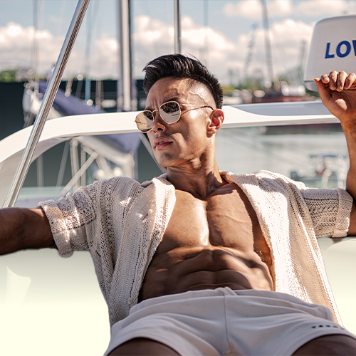 Andee Teo wearing sunglasses is sitting on a boat