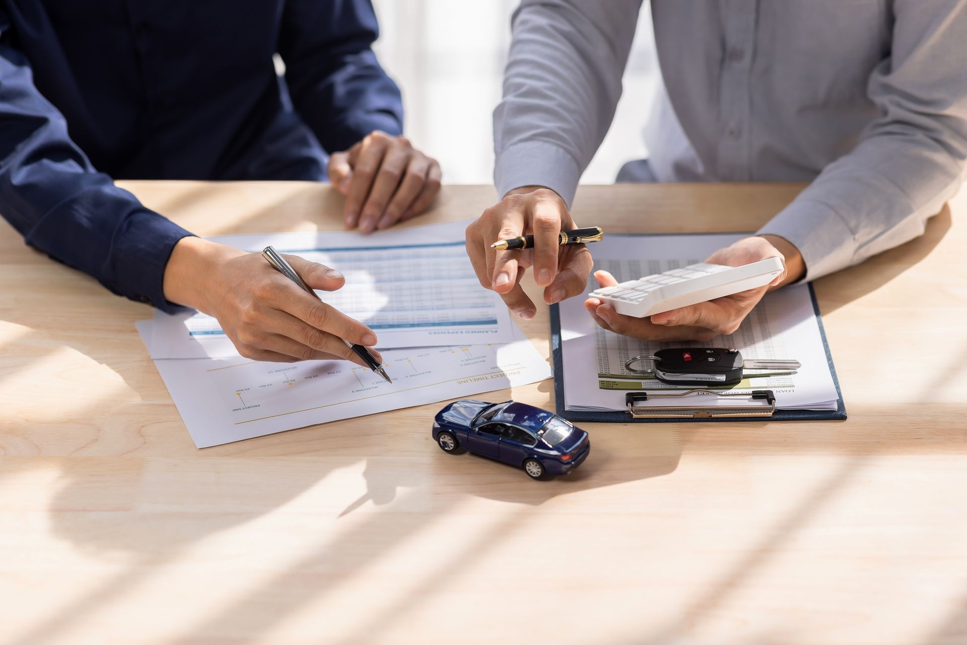 Client signing auto insurance agreement with a Michael McGowen Insurance agent, finalizing car insurance contract