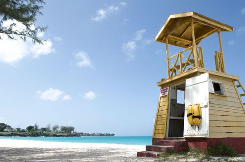 Yellow lifeguard tower on a tropical beach with turquoise water and blue sky