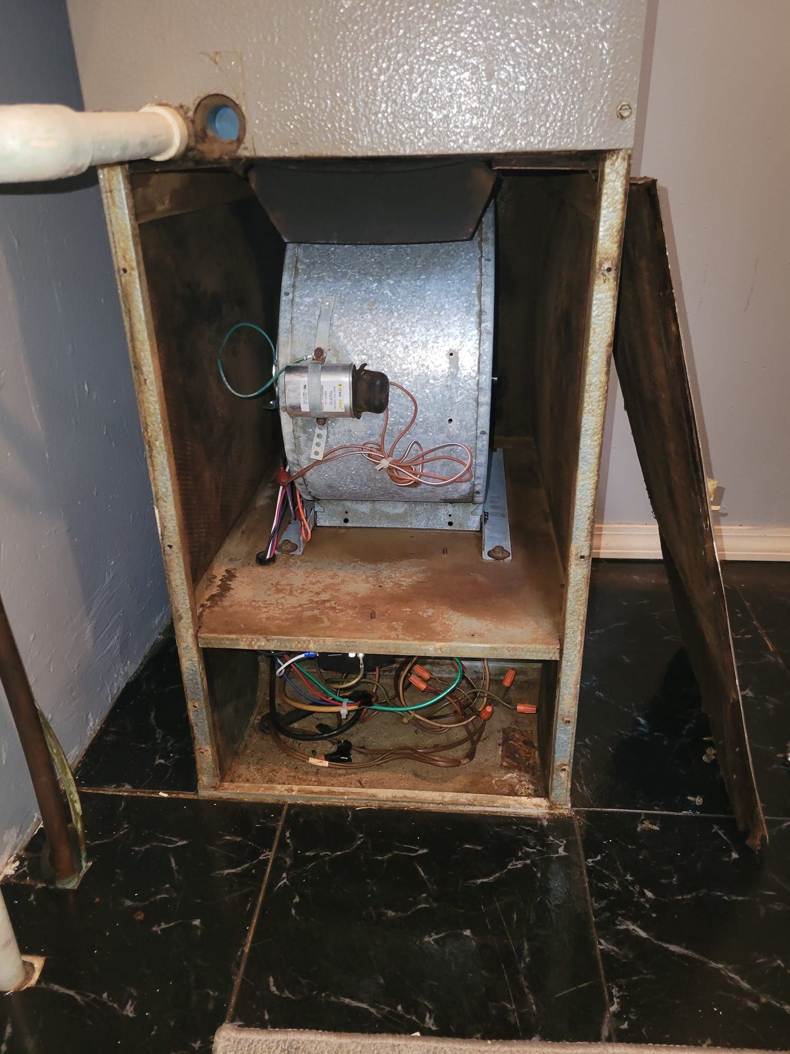 A furnace is sitting on a tiled floor in a room.