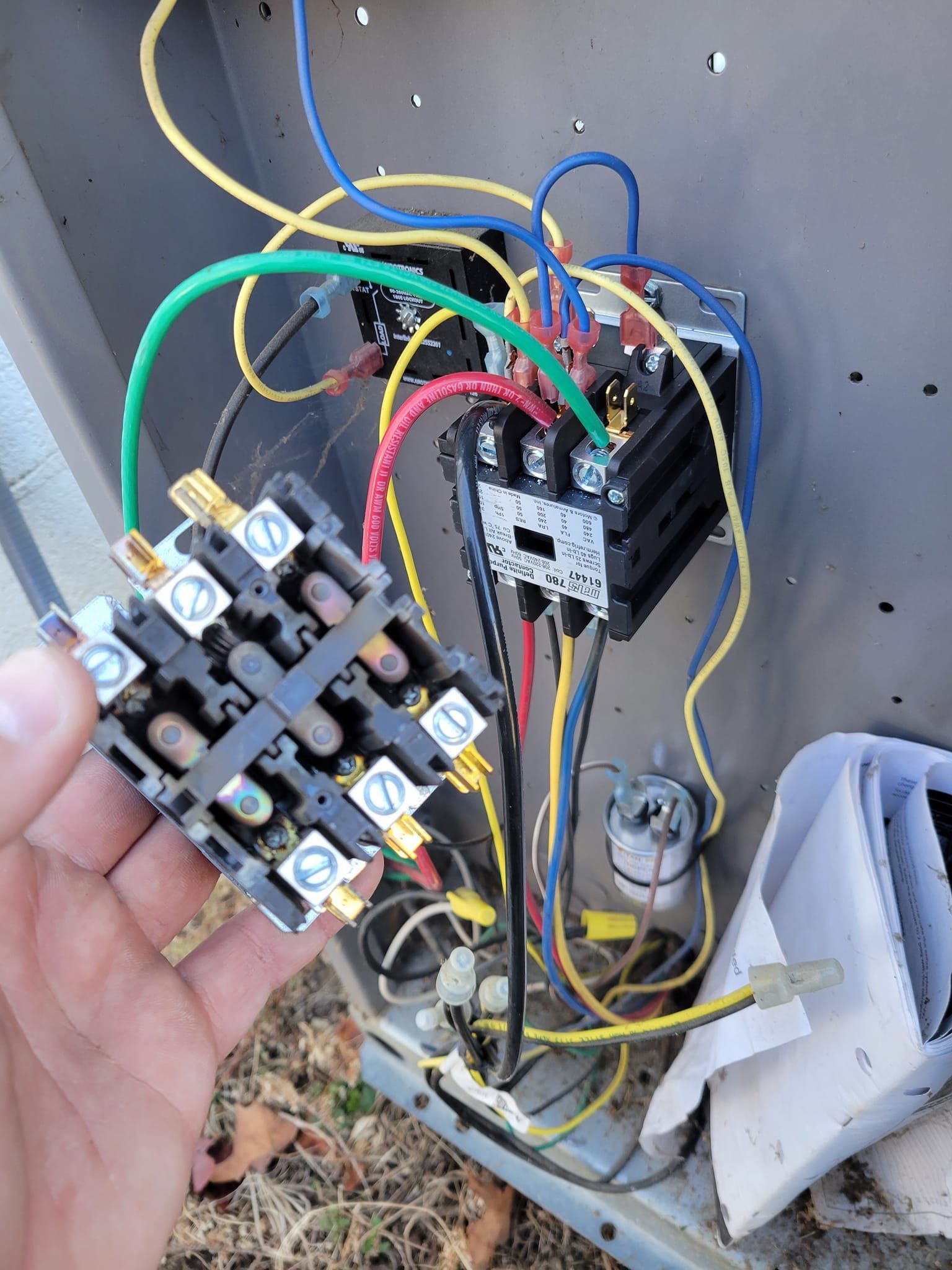 A person is holding a piece of electrical equipment in their hand.