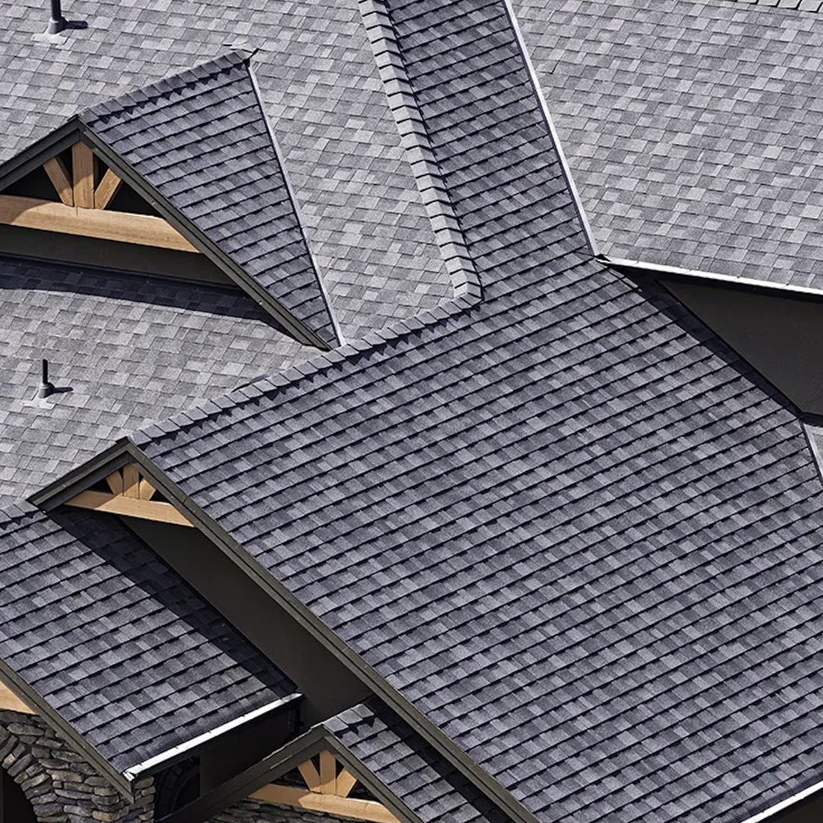 Dark gray shingled roof with intersecting gables and small dormer windows