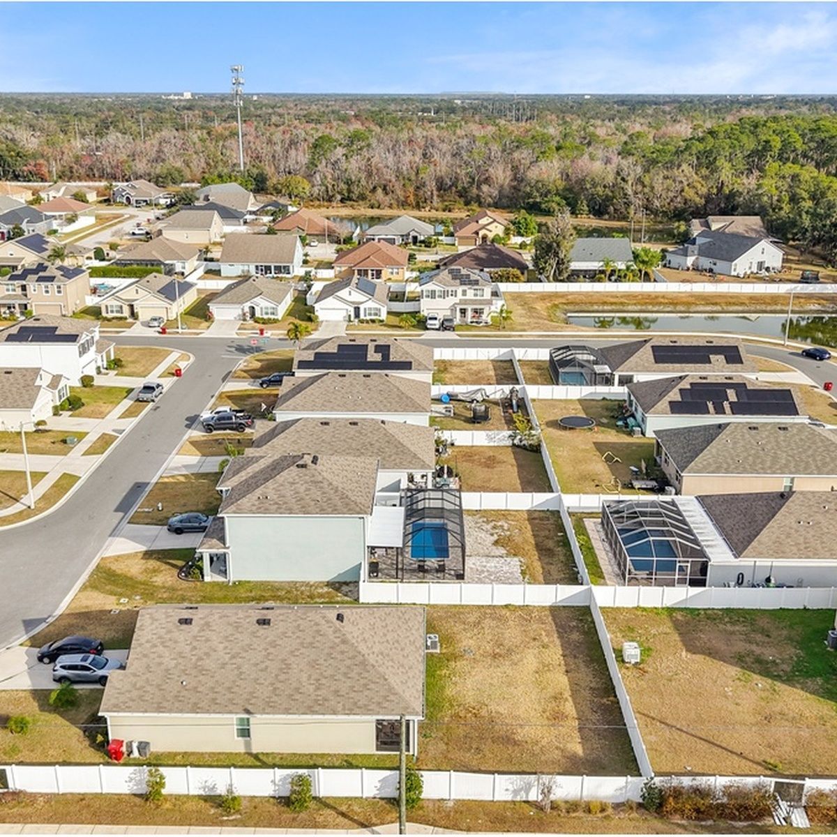 Aerial view of a suburban neighborhood with homes, streets, and trees in the distance.