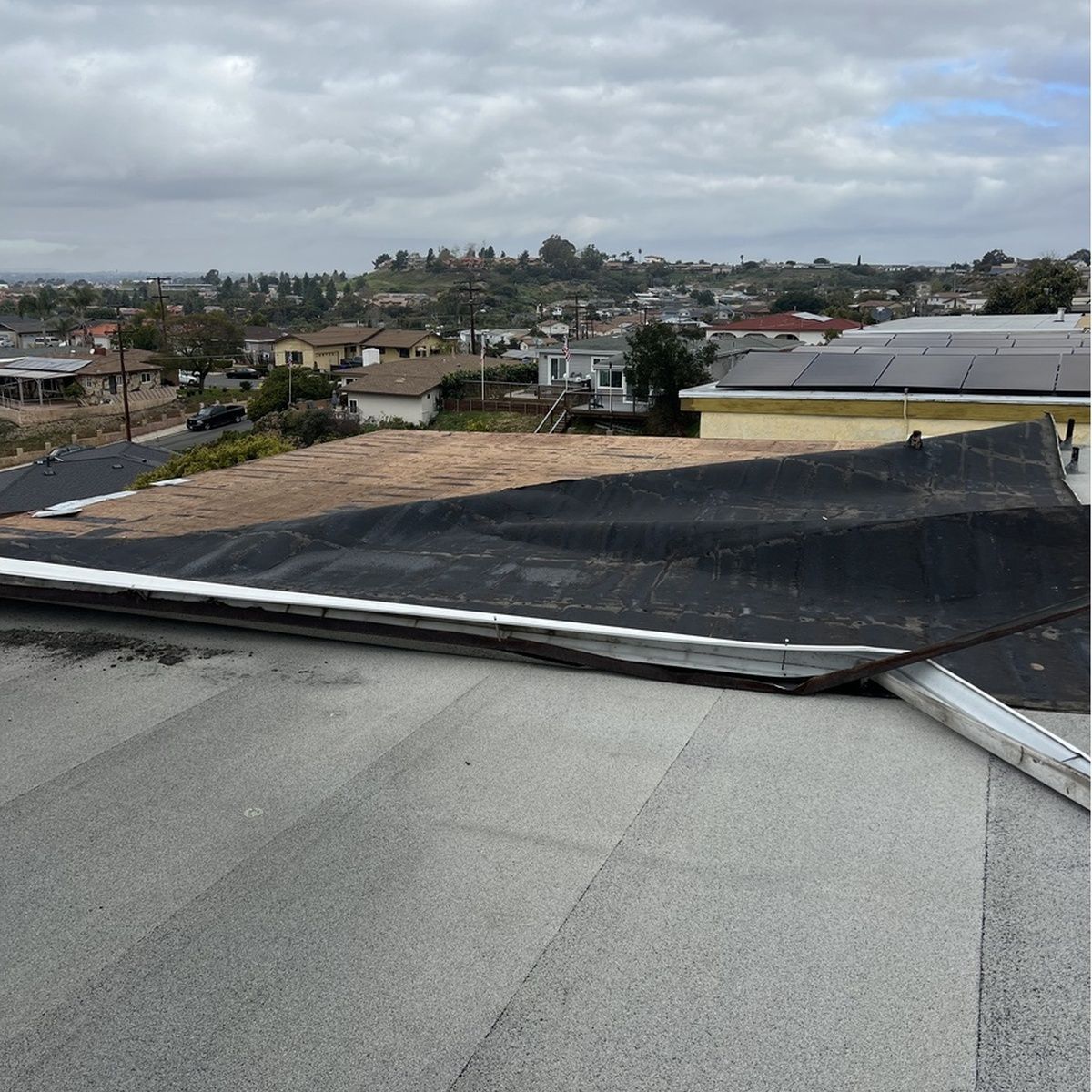 Rooftop view over a suburban neighborhood under cloudy skies.