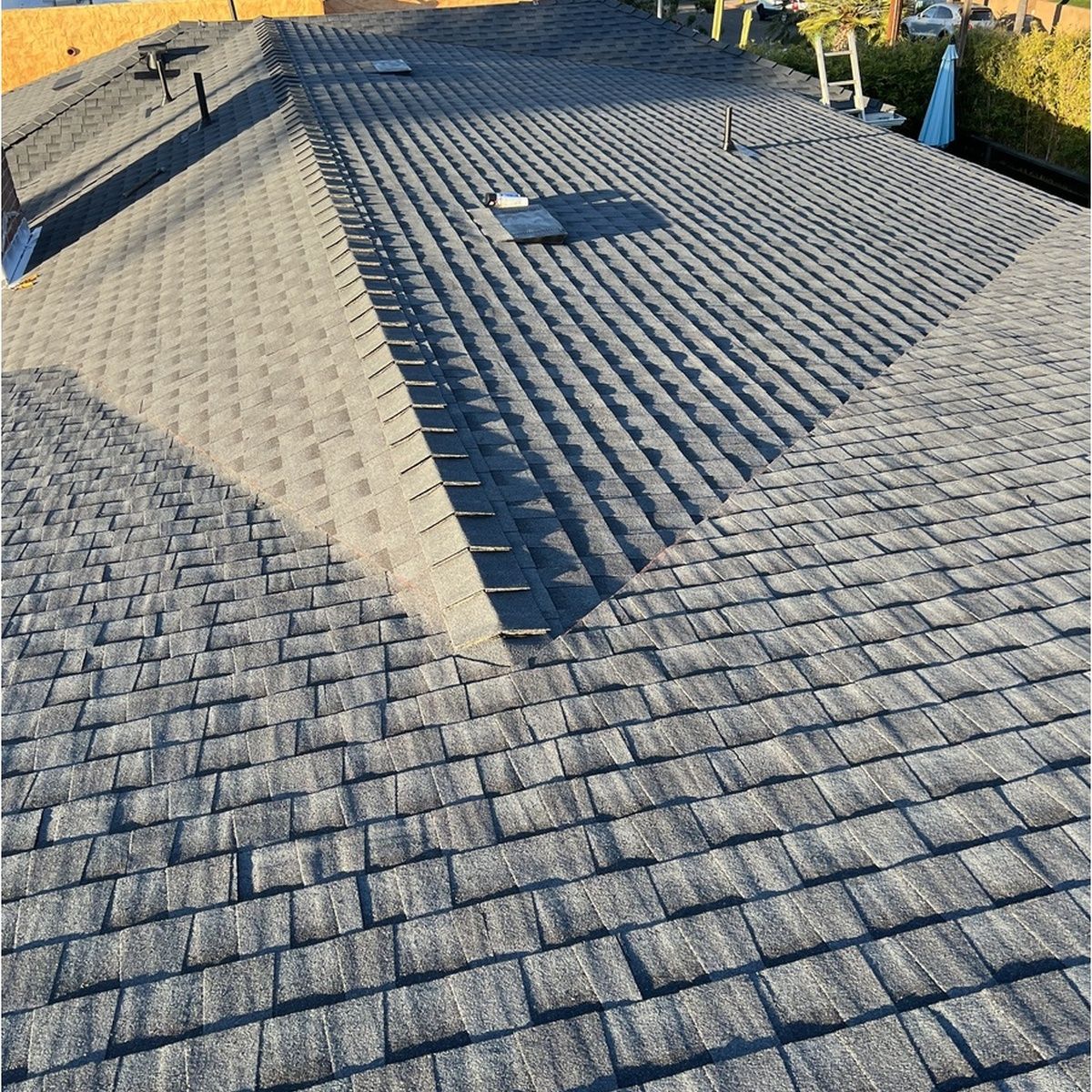 Gray shingled roof with a large triangular shadow and a small roof vent near the center.
