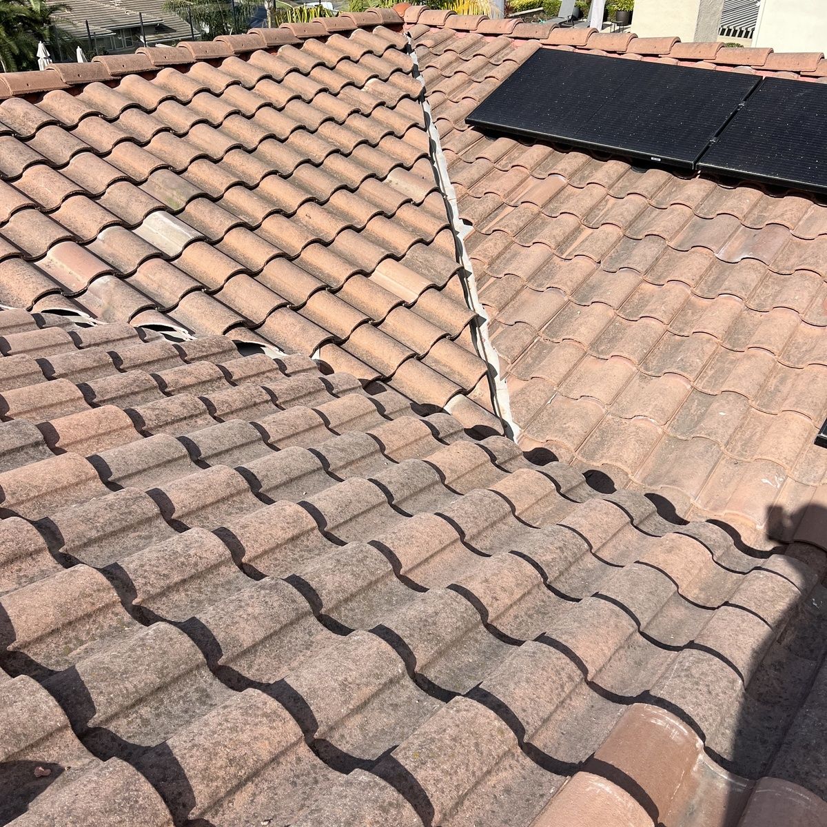 Tiled roof with dark solar panel and visible ridge seam