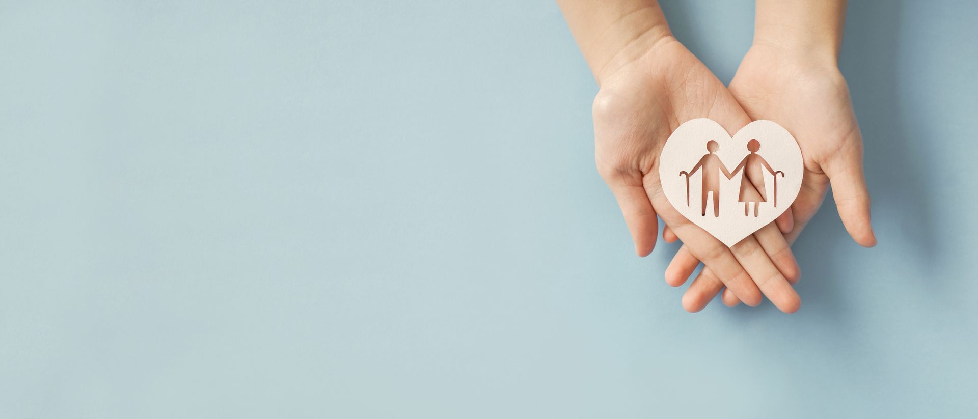 Hands holding a white circle with family icons on a light blue background
