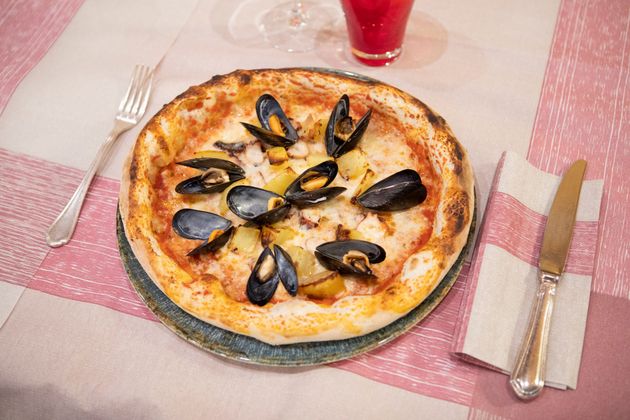 Un vassoio d'argento contiene quattro ciotole di rame piene di piatti indiani: riso bianco, curry rosso, curry giallo e curry verde.