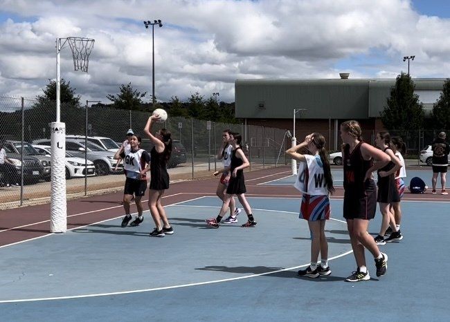 A group of girls are playing a game of netball