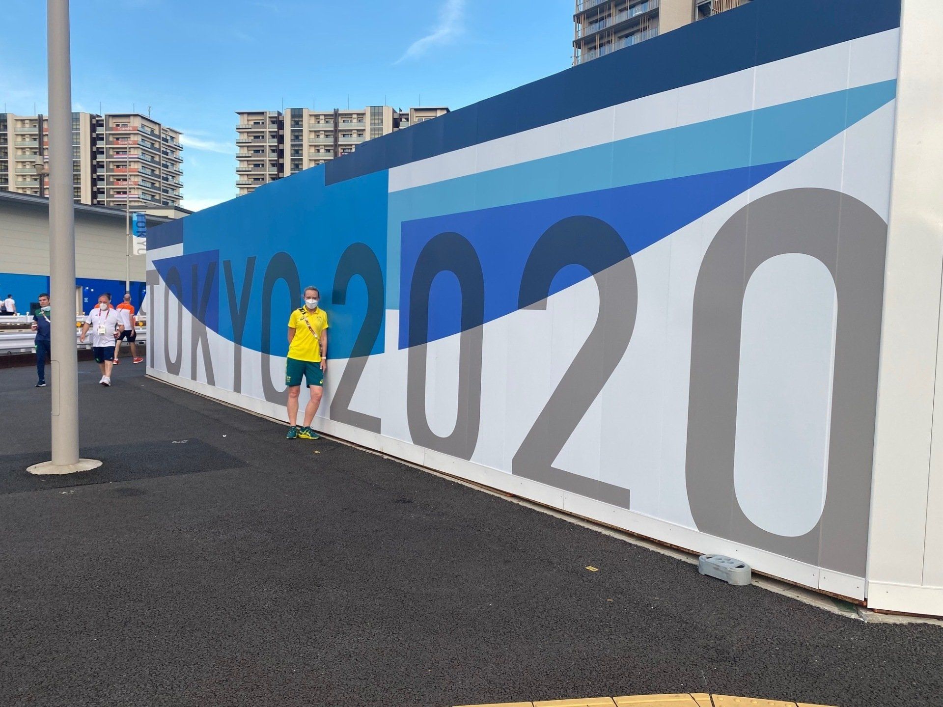 People standing in front of a wall that says tokyo 2020