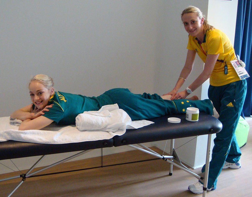 A woman in a yellow shirt is giving a woman a massage