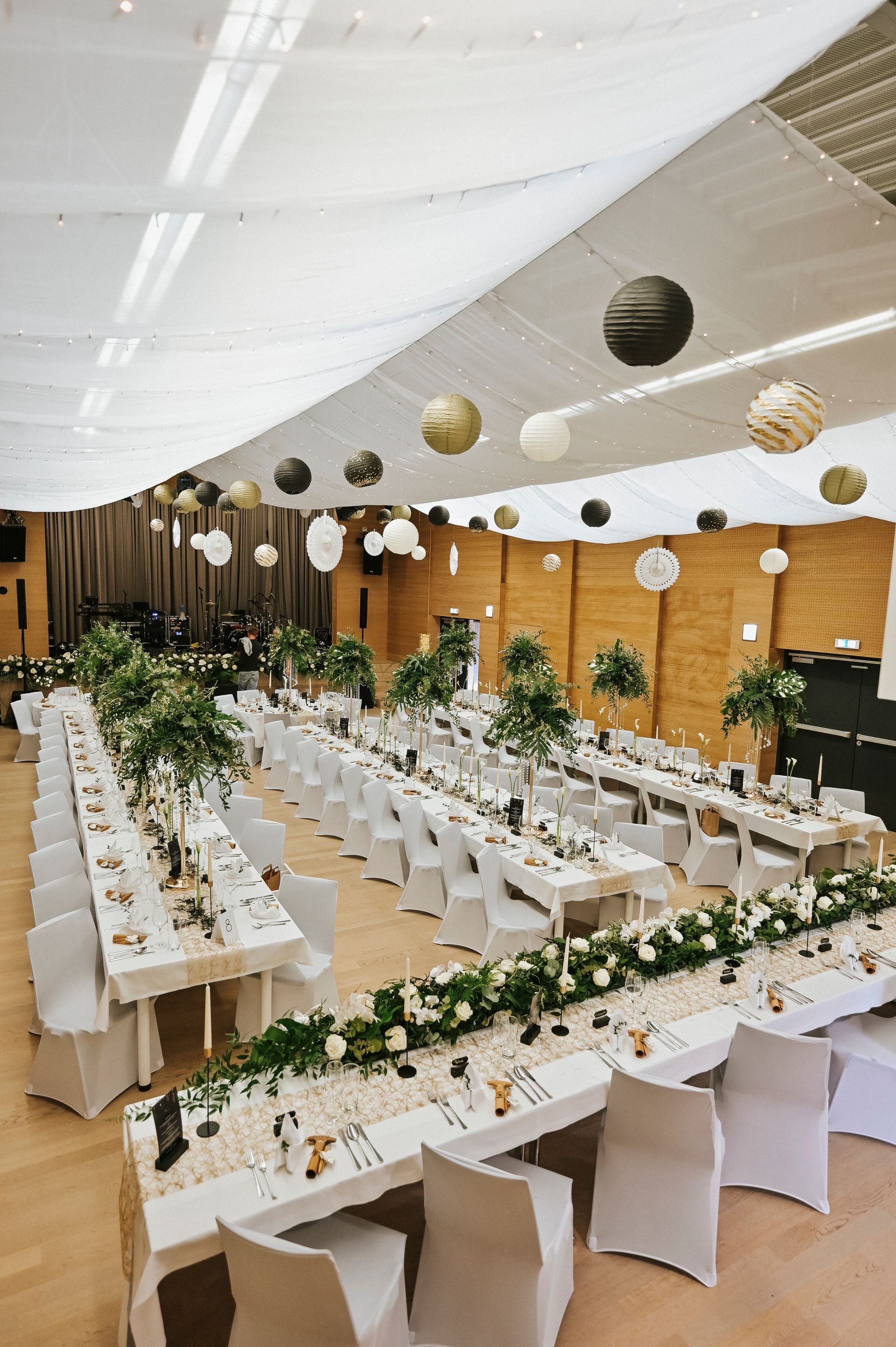 Ein großer Raum mit Tischen und Stühlen für einen Hochzeitsempfang.