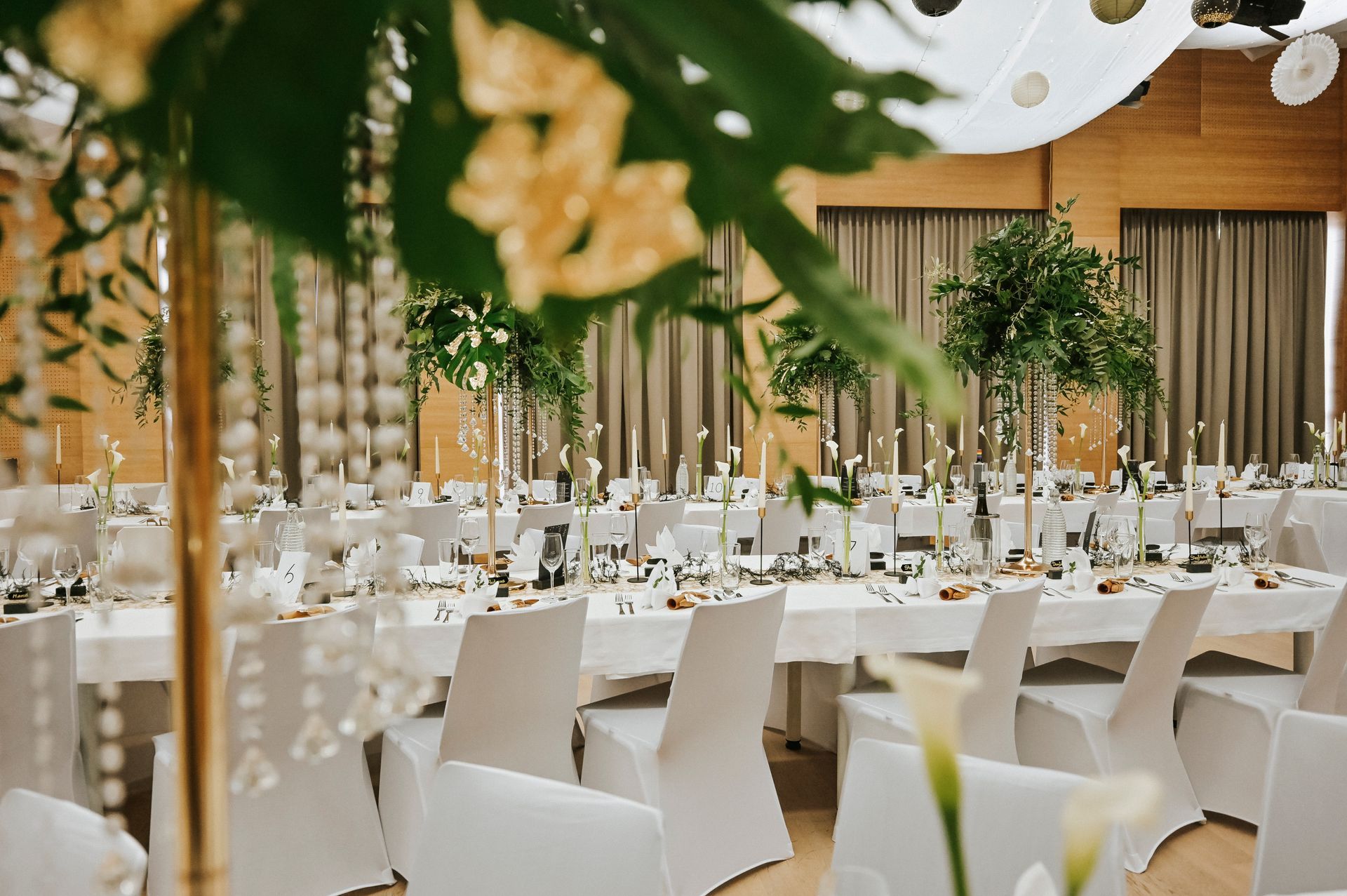 Ein großer Raum mit Tischen und Stühlen für einen Hochzeitsempfang.