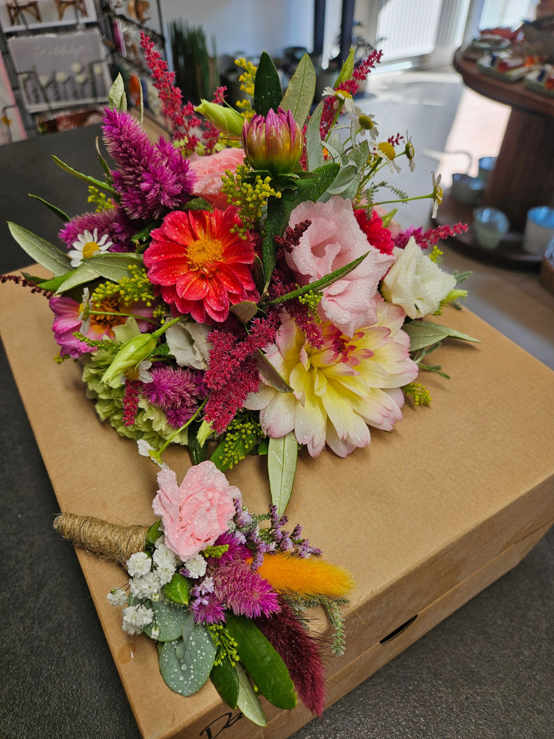 Auf einem Tisch steht eine Schachtel voller Blumen.