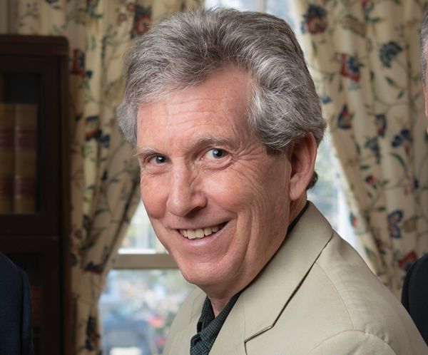 Michael A Fuerst is smiling in front of a window