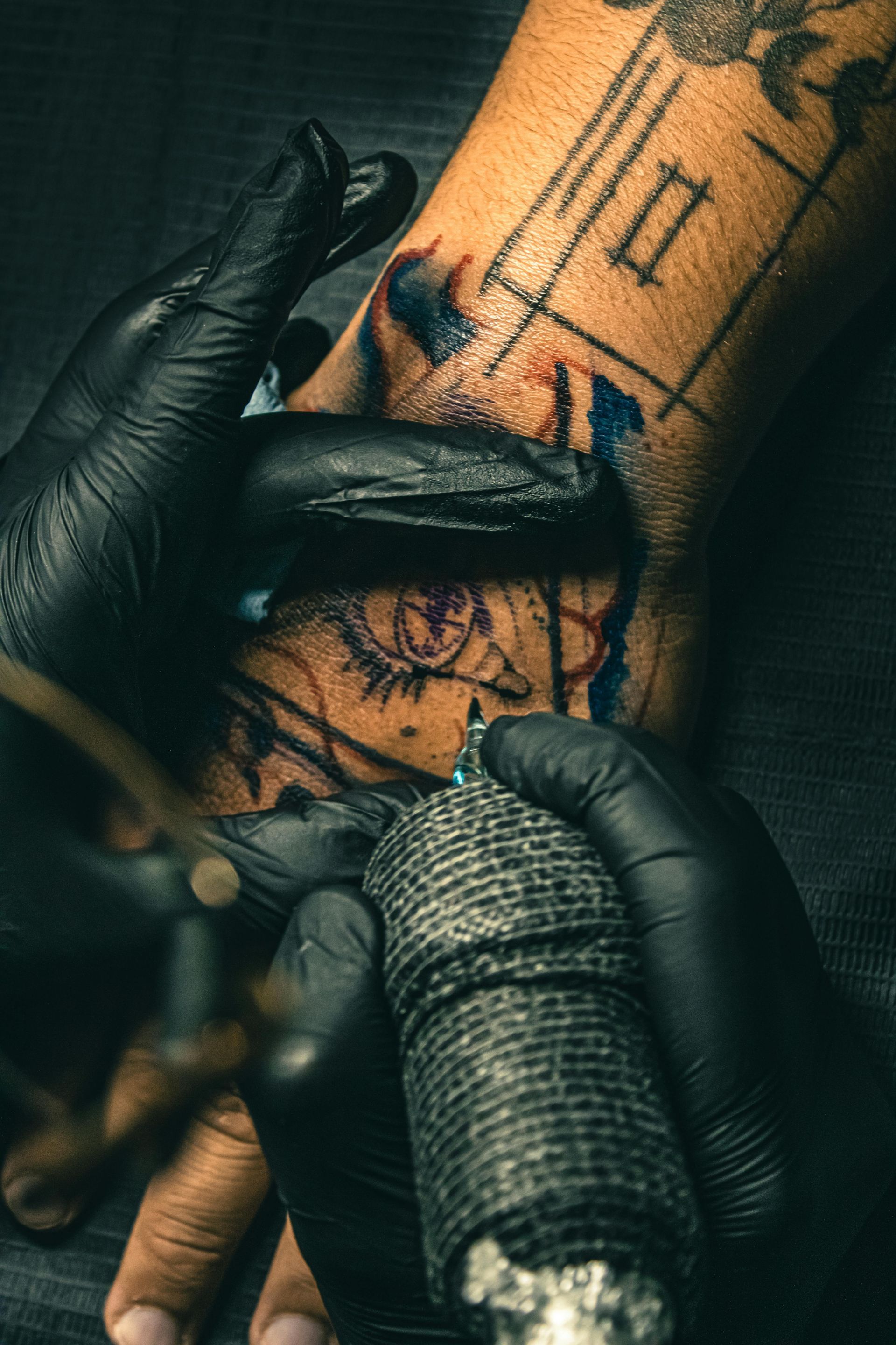 Gloved Hands Tattooing a Forearm — Laserpro Tattoo Removal in Shellharbour, NSW