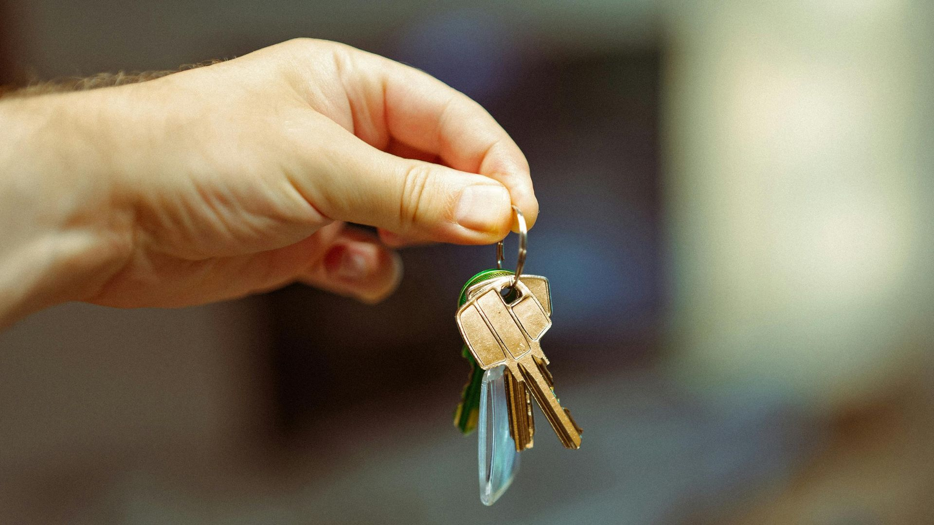 An outstretched hand holding a set of keys.