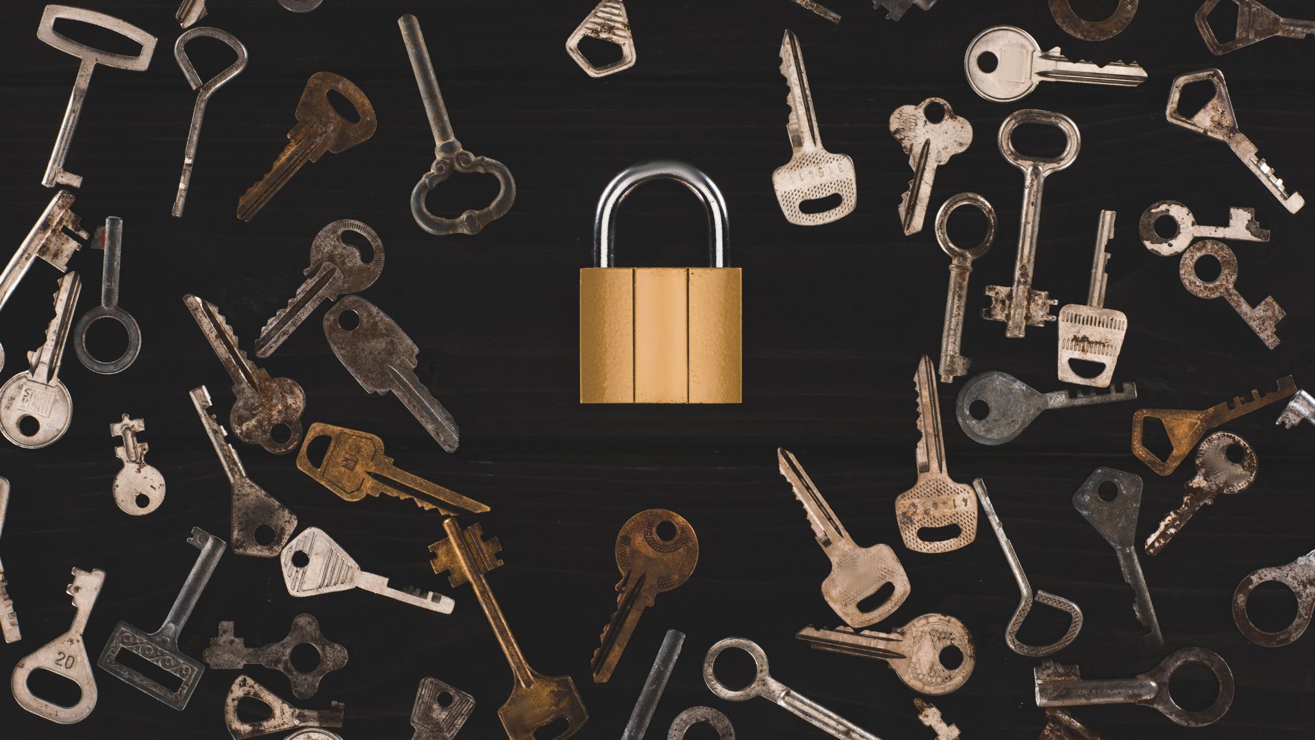 A gold padlock surrounded by a range of keys