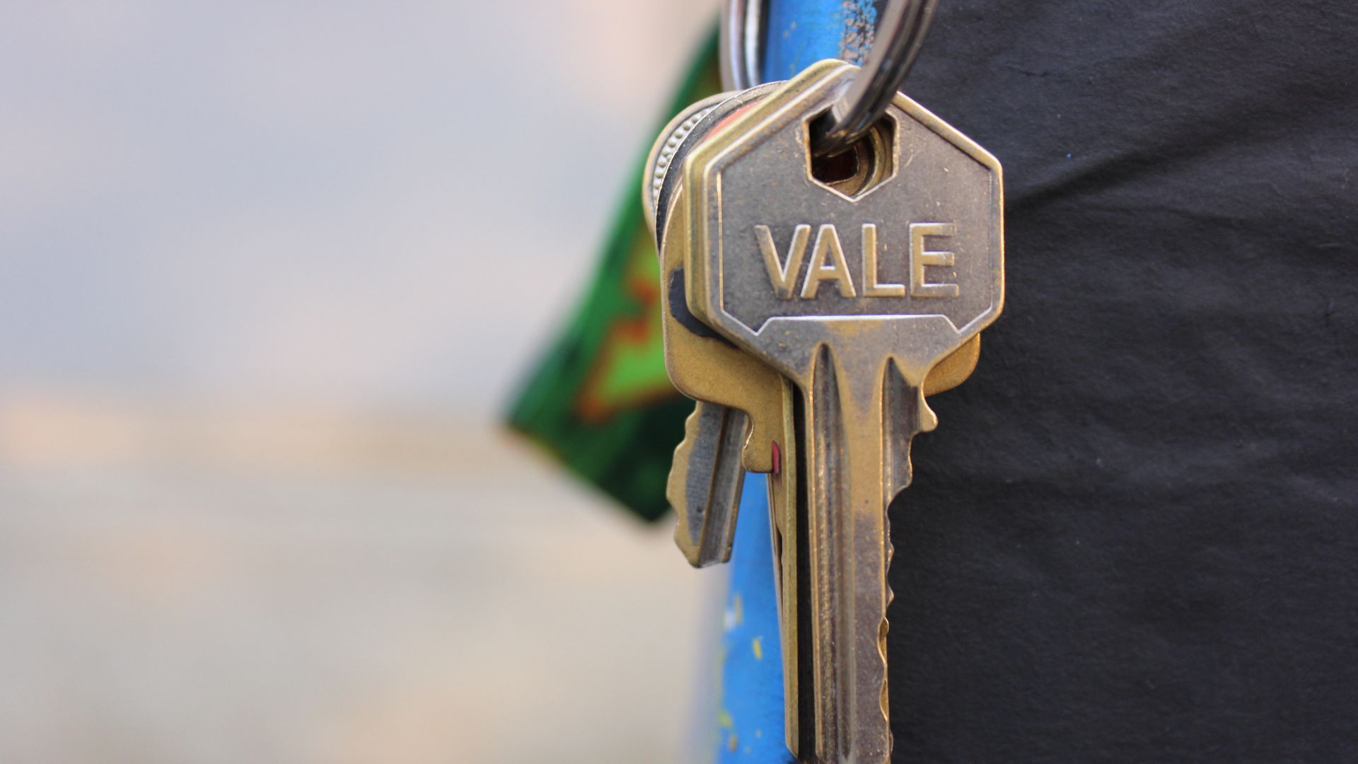 A set of keys hanging out of a person’s trouser pocket, the front key marked ‘VALE’.