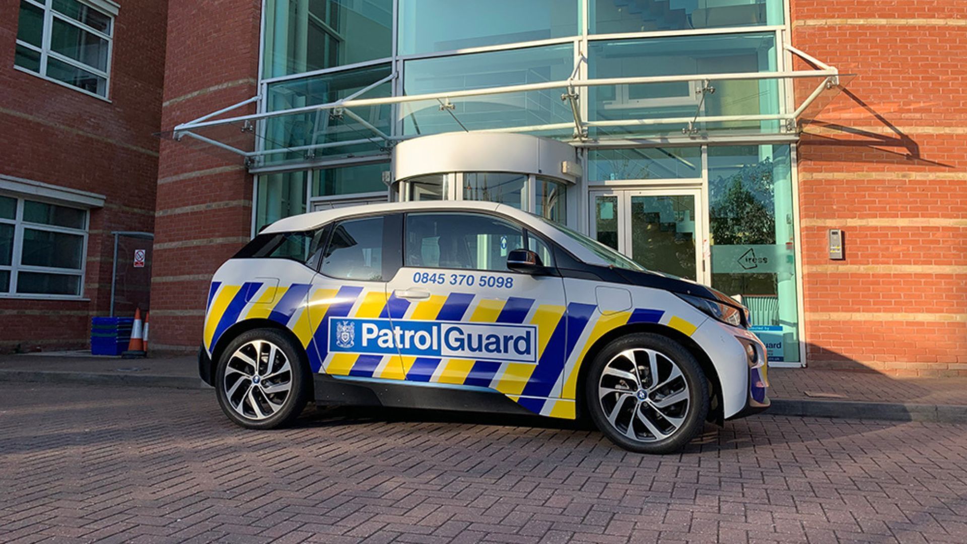 A branded PatrolGuard vehicle parked outside an office building.