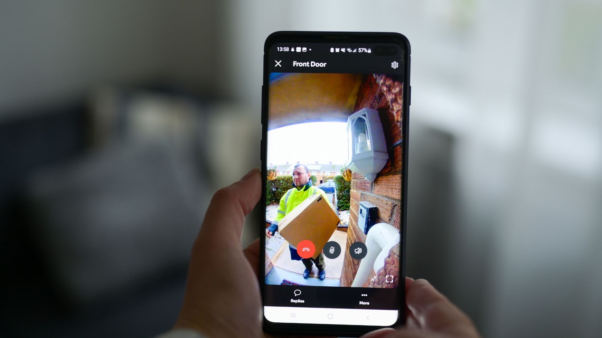 A smartphone showing a parcel being delivered, captured on a doorbell camera.
