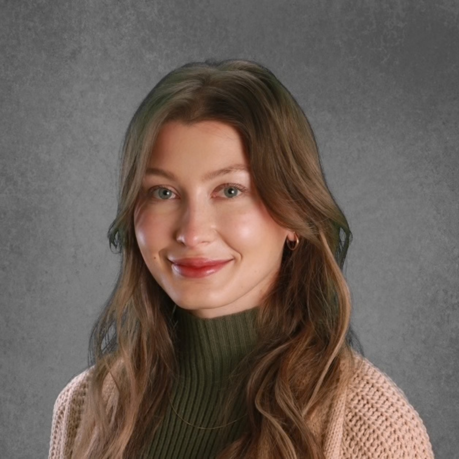 Portrait of a smiling person in a brown sweater against a gray studio background