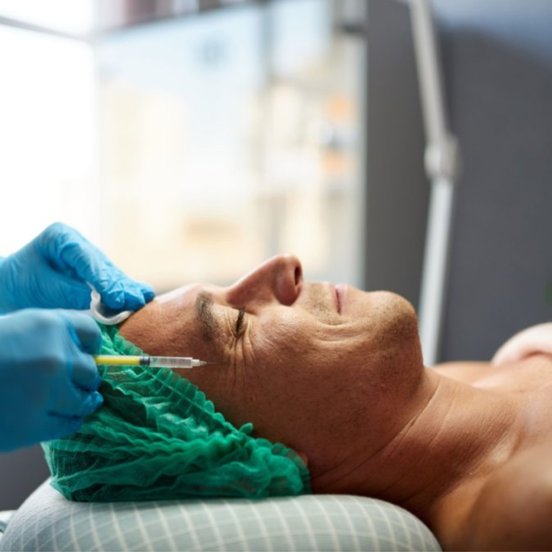 Cosmetic procedure on face with gloved hands and green hair net in a clinical setting