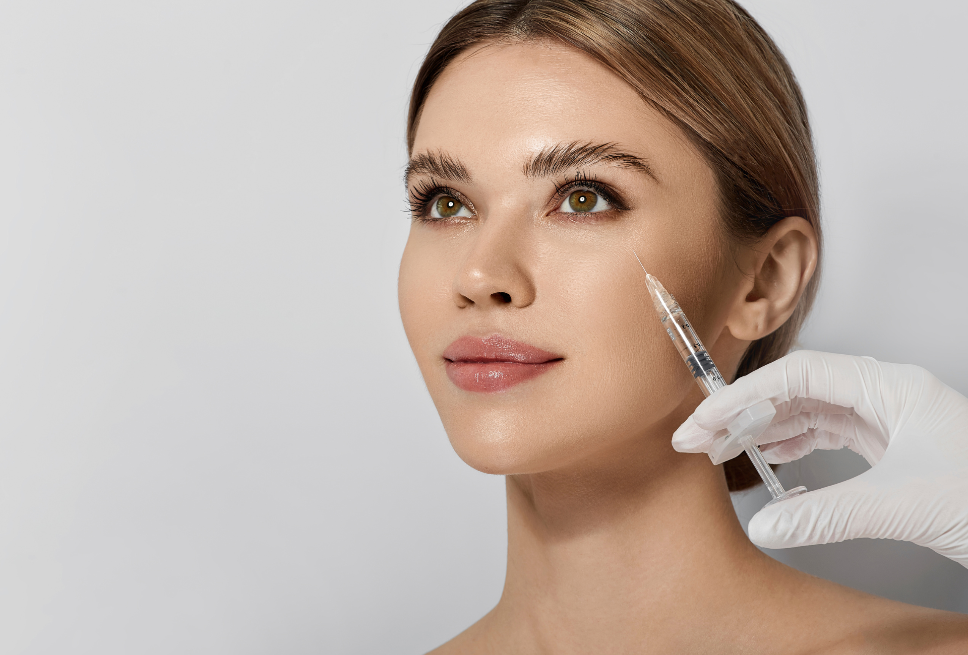 A woman is getting a botox injection in her face.