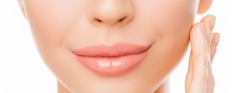 A close up of a woman 's face with her hand on her chin.