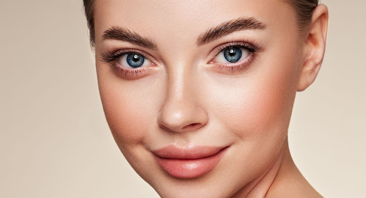 A close up of a woman 's face with blue eyes.