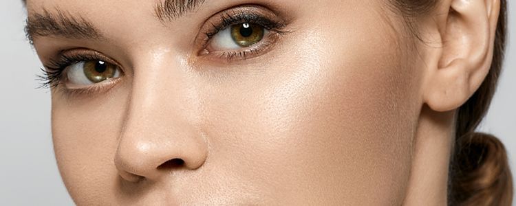 Close-up of a person's face with light skin and hazel eyes, looking slightly to the side.