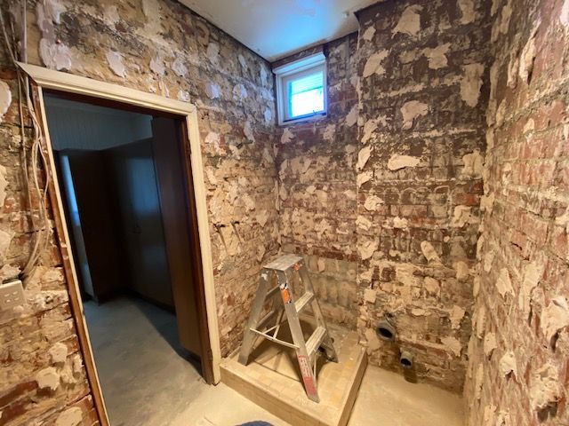 Room with exposed brick walls, small window, and step stool — Mezcon Renovations & Maintenance in Heidelberg, VIC