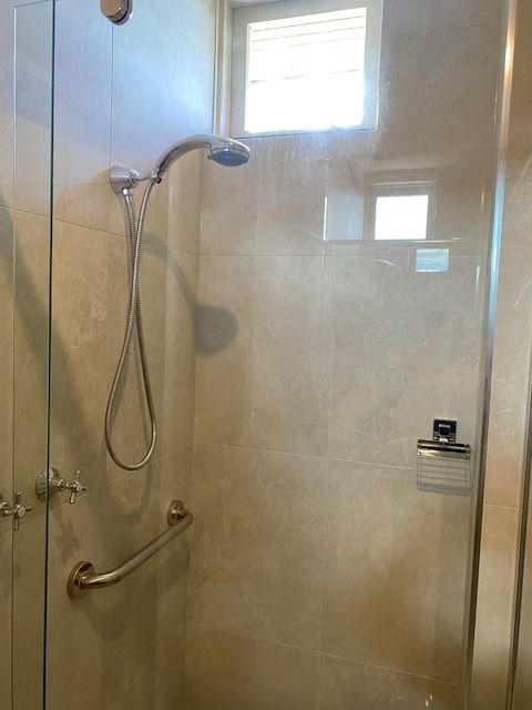Shower stall with glass doors, grab bar, handheld showerhead — Mezcon Renovations & Maintenance in Heidelberg, VIC