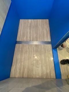 Two rectangular gray-beige tiles with a linear drain — Mezcon Renovations & Maintenance in Heidelberg, VIC